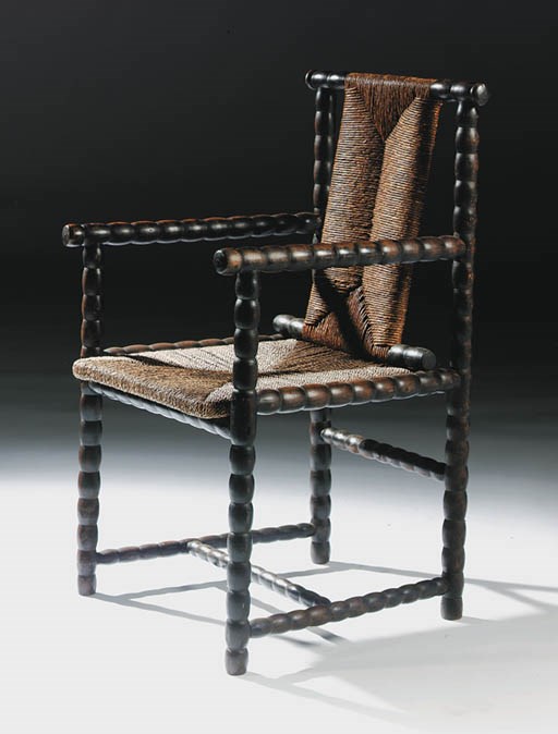 An ebonised maplewood and rush seat armchair