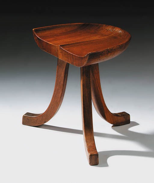 A cherrywood three-legged stool