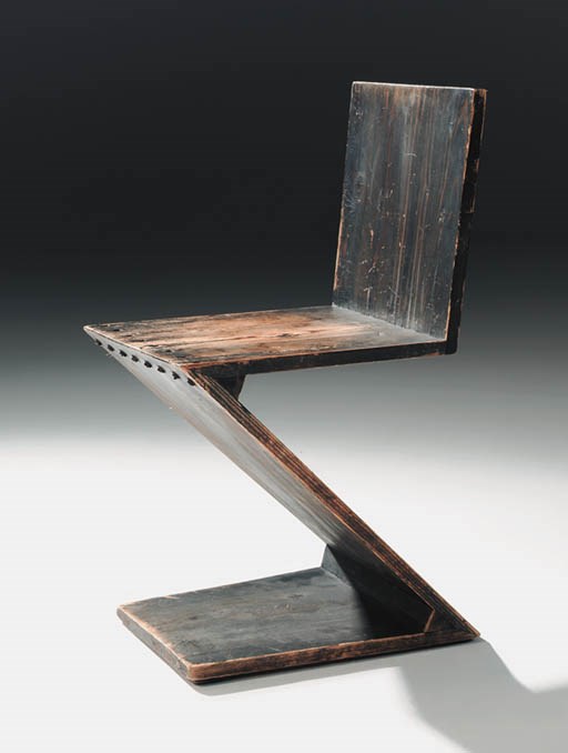 A grey painted zig-zag chair