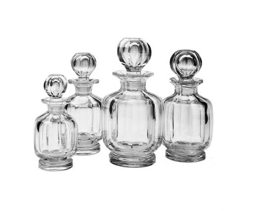 A SET OF FOUR CUT COLORLESS GLASS DECANTERS AND STOPPERS
