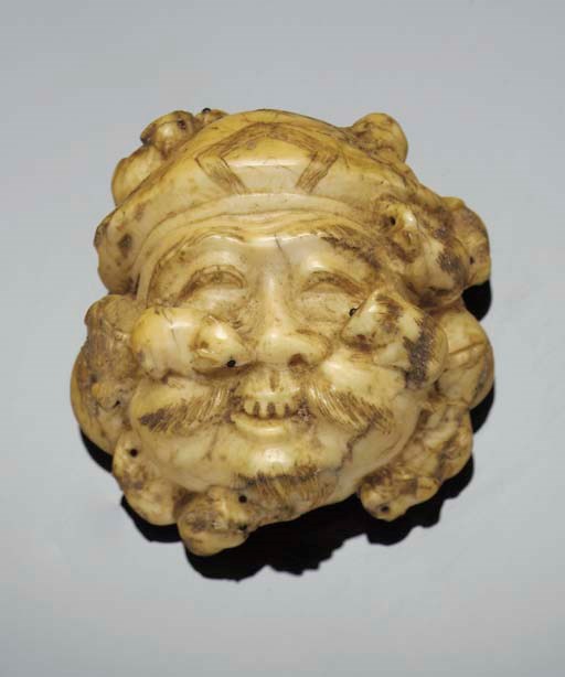 A Japanese ivory netsuke of a mask of Daikoku, 19th century