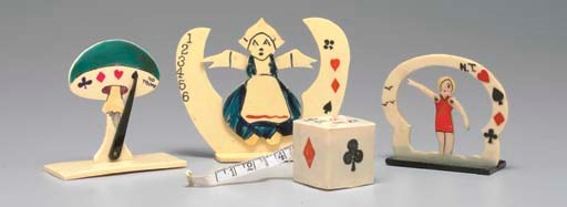 A GROUP OF FOUR CELLULOID TRUMP INDICATORS IN THE SHAPE OF A MUSHROOM, A CUBE WITH TAPE MEASURE, A DUTCH WOMAN, AND A BATHING GIRL.