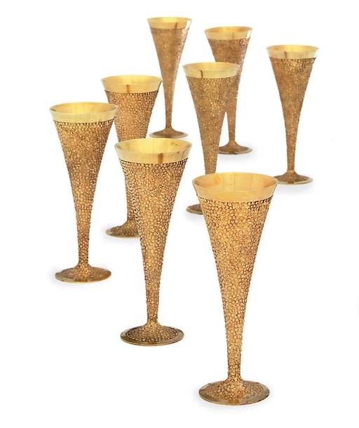A SET OF EIGHT ELIZABETH II SILVER-GILT CHAMPAGNE FLUTES