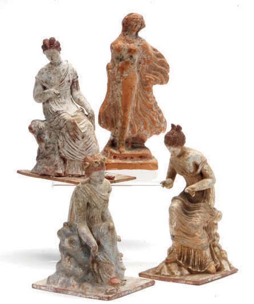 A GREEK TERRACOTTA FEMALE FIGURE IN A BILLOWING MANTLE,