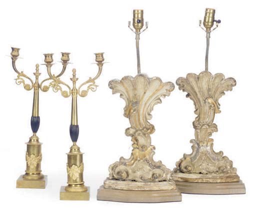 A PAIR OF CARVED AND PAINTED CARTOUCHE TABLE LAMPS WITH A PAIR OF GILT-METAL CANDELABRA,