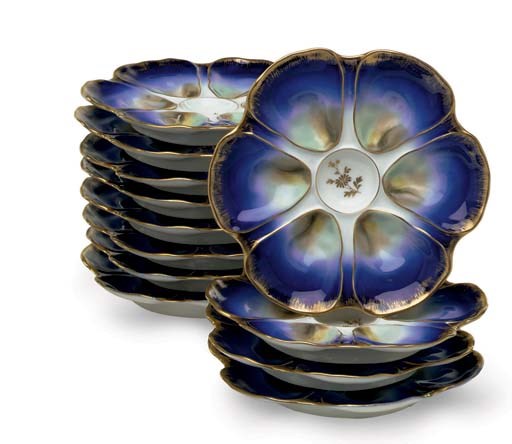 TWELVE LIMOGES PORCELAIN OYSTER PLATES AND TWO CONTINENTAL POTTERY BOLD AND SILVER LUSTRE DISHES