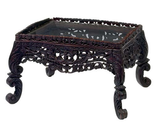 A GLASS-INSET CARVED HARDWOOD RECTANGULAR TABLE