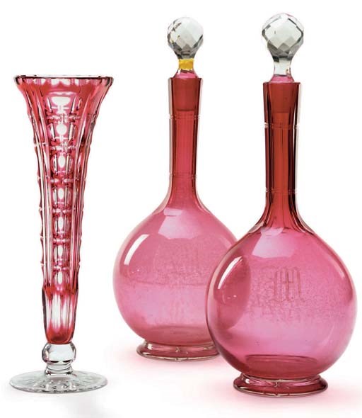 A PAIR OF CONTINENTAL MONOGRAMMED TRANSLUCENT CRANBERRY GLASS DECANTERS AND TWO STOPPERS AND A BOHEMIAN RUBY-OVERLAY CUT-GLASS BUD VASE