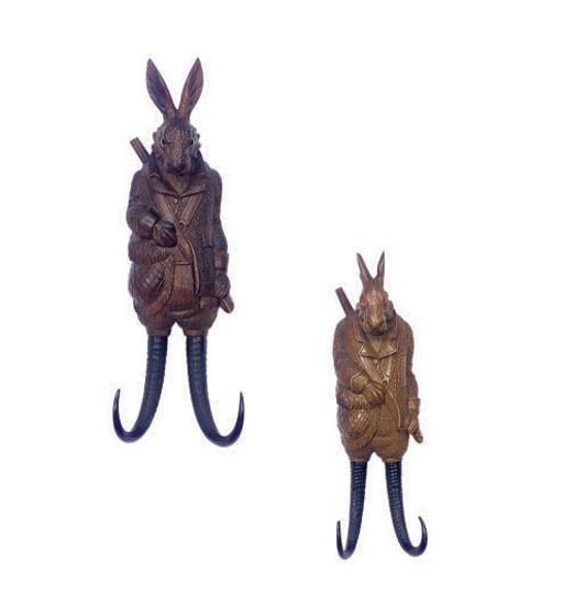 TWO BLACK FOREST CARVED MUSIC BOXES/COAT HOOKS IN THE FORM OF RABBITS,