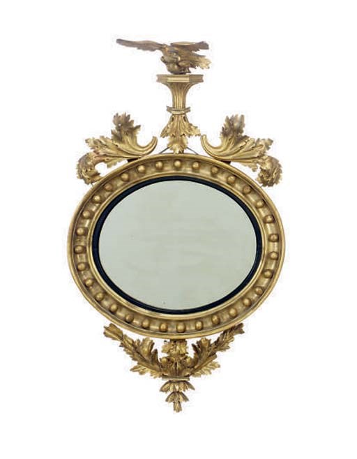 A REGENCY CARVED GILTWOOD AND COMPOSITION CONVEX MIRROR,