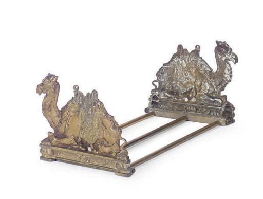 A GILT AND PAINTED BRONZE CAMEL-FORM BOOK RACK,