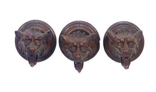 A GROUP OF THREE CAVED WOLF-FROM CURTAIN TIE-BACKS,
