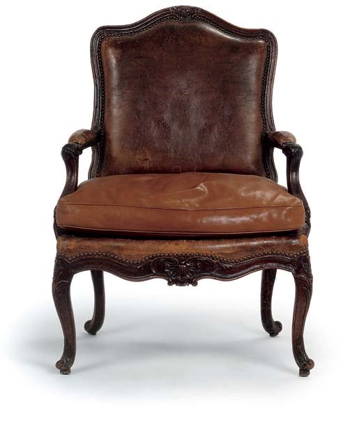 AN EARLY LOUIS XV WALNUT AND CLOSE-NAILED BROWN-LEATHER UPHOLSTERED FAUTEUIL
