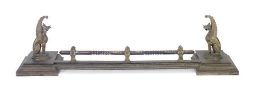 A GILT-BRONZE FIREPLACE FENDER WITH GRIFFIN MOUNTS,