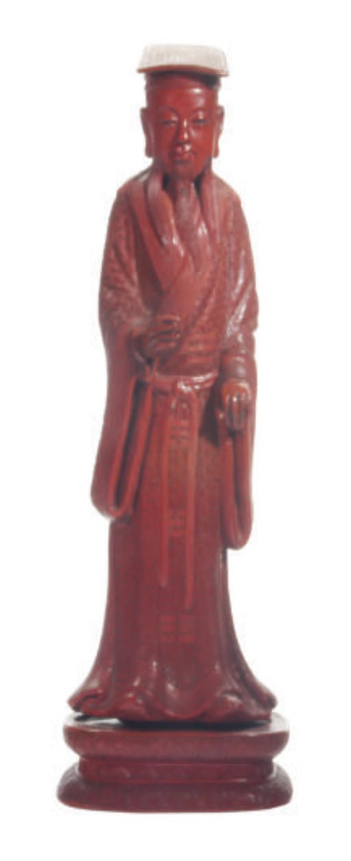 A CHINESE CARVED RED LACQUER FIGURE OF A DAOIST IMMORTAL AND STAND,