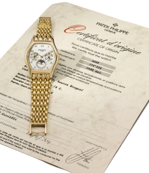 Patek Philippe. A fine 18K gold self-winding tonneau-shaped perpetual calendar wristwatch with phases of the moon, bracelet and original certificate