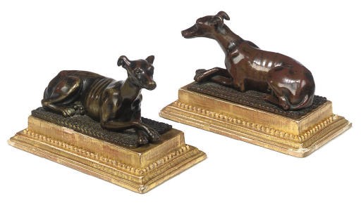 A PAIR OF REGENCY BRONZE MODELS OF RECUMBENT GREYHOUNDS