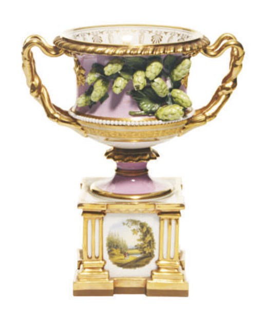 AN ENGLISH PORCELAIN PINK GROUND 'WARWICK' VASE WITH APPLIED HOP DECORATION ON FIXED ARCHITECTURAL STAND,