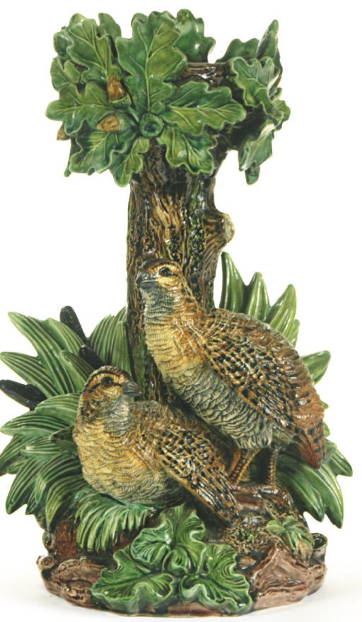 A MAJOLICA RUSTIC CANDLESTICK AS TWO PARTRIDGE AT THE FOOT OF AN OAKTREE,