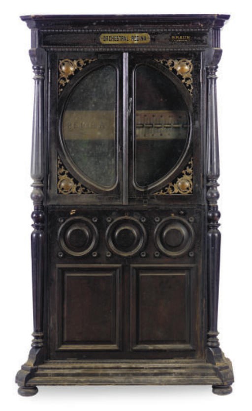 A REGINA OAK CASED UPRIGHT MUSIC BOX,