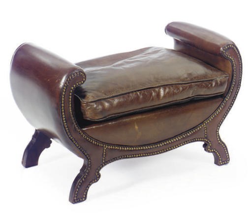 A BROWN LEATHER UPHOLSTERED SCROLL-FORM FOOT STOOL,