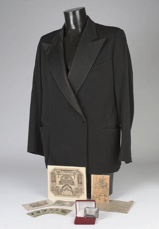 A quantity of ephemera relating to Mstislav Valer'ianovich Dobuzhinsky including a drawn New Year's card from 1956, the artist's jacket, his snuff box, a photo of the artist, a printed New Year's card for 1912, a cigar box cover, a backboard, a pamphlet and thirteen bookplates for the artist's son, Valer'ian Dobuzhinsky	 (22)