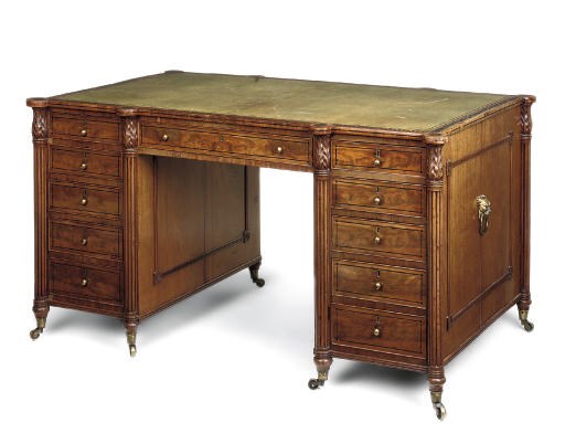 A LATE REGENCY EBONY STRUNG MAHOGANY KNEEHOLE PARTNERS' DESK