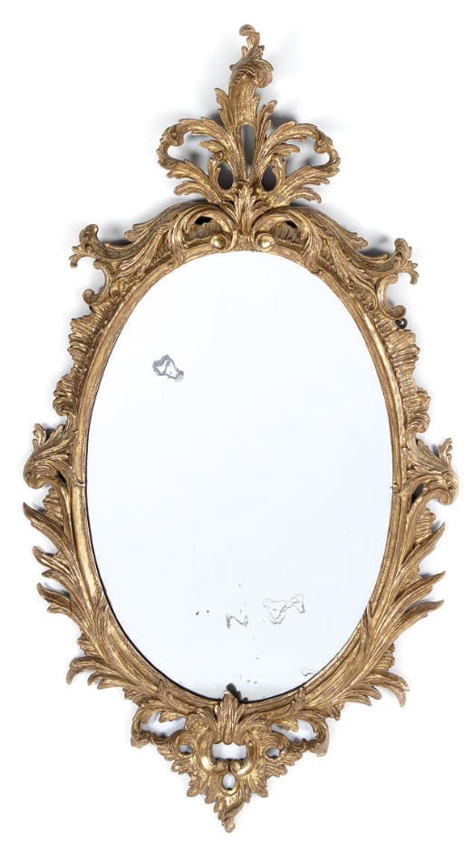 A CARVED GILTWOOD OVAL WALL MIRROR