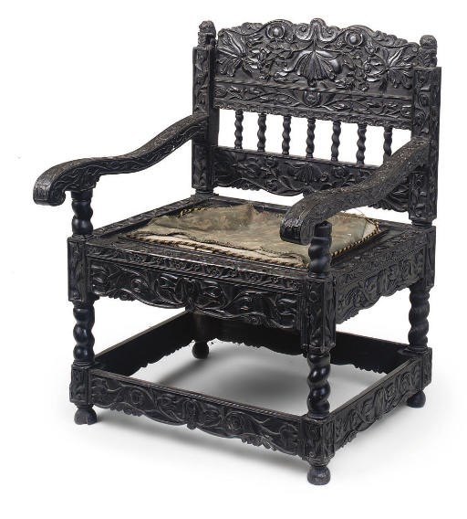 A CARVED EBONY ARMCHAIR