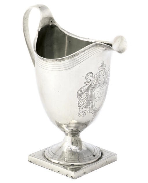 A GEORGE III SILVER HELMET CREAM JUG ON A SQUARE FOOT