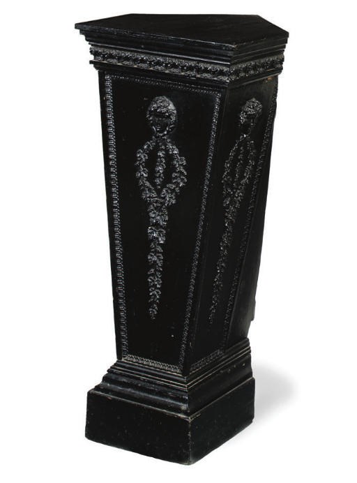 A CARVED COMPOSITION AND EBONISED CORNER PEDESTAL