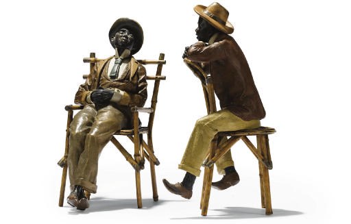 A PAIR OF AUSTRIAN POLYCHROME-DECORATED TERRACOTTA SEATED FIGURES