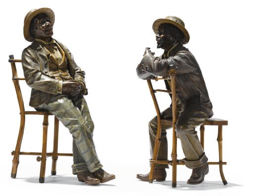 A PAIR OF AUSTRIAN POLYCHROME-DECORATED TERRACOTTA SEATED FIGURES