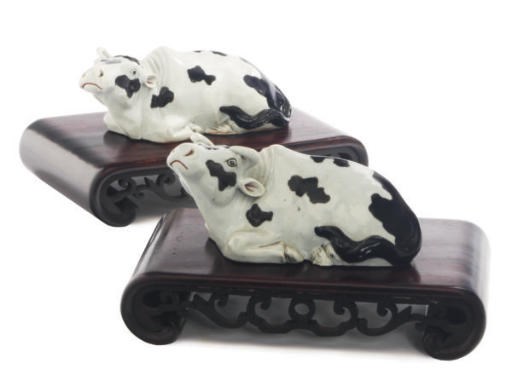 A PAIR OF CHINESE EXPORT PORCELAIN MODELS OF RECUMBENT COWS,