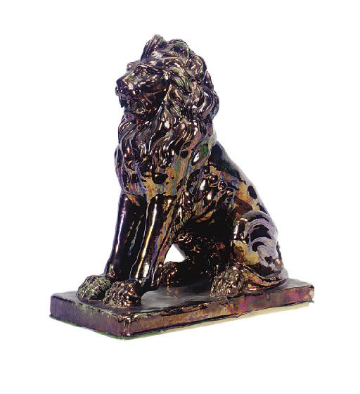A SPANISH IRIDESCENT GLAZED CERAMIC STATUE OF A SEATED LION,
