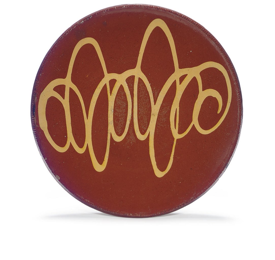 A SLIP-DECORATED REDWARE CHARGER