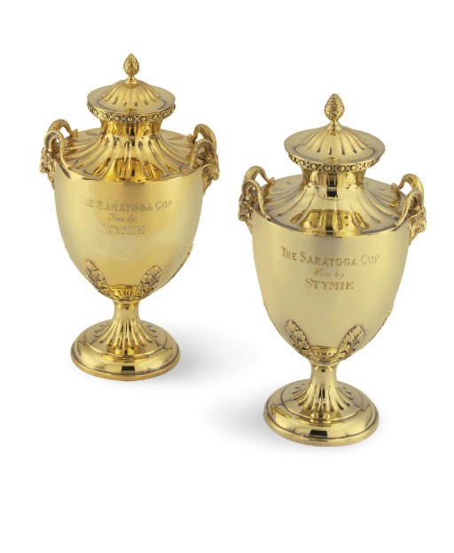 A MATCHED PAIR OF SILVER-GILT TROPHY CUPS AND COVERS: THE SARATOGA CUP, WON BY STYMIE