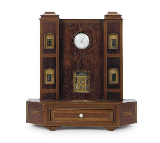 A MIXED WOOD ARCHITECTURAL FORM POCKET-WATCH STAND WITH DRAWER,