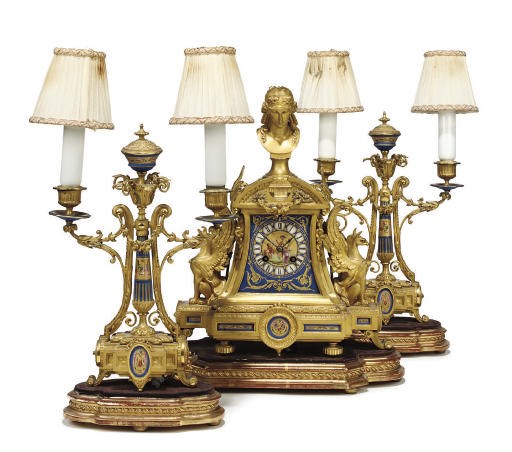 A FRENCH GILT-BRONZE AND ENAMEL MOUNTED MANTEL CLOCK AND GARNITURE