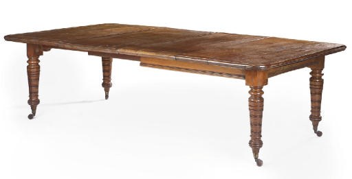 A MID VICTORIAN OAK EXTENDING DINING TABLE
