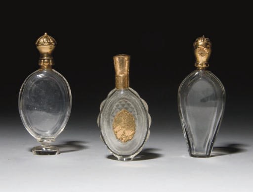 TROIS FLACONS A PARFUM ET DEUX BOUCHONS EN VERRE A MONTURE EN OR DU XIXEME SIECLE