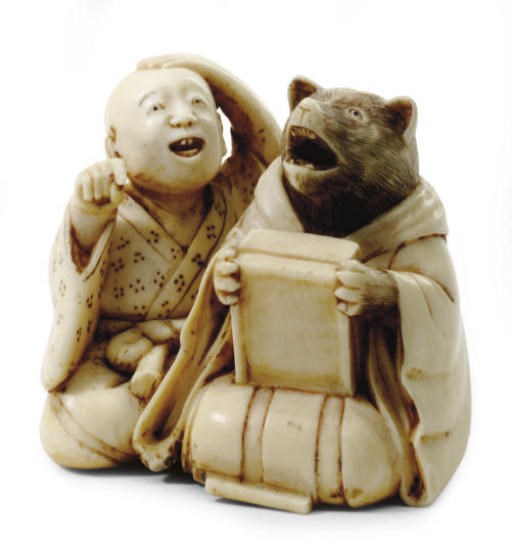 A JAPANESE IVORY NETSUKE OF A BUDDHIST PRIEST TEACHING A BADGER,