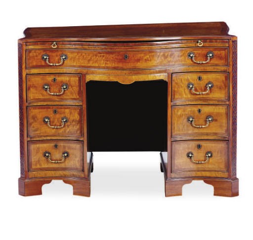 AN ENGLISH MAHOGANY AND WALNUT SERPENTINE KNEE-HOLE DESK,