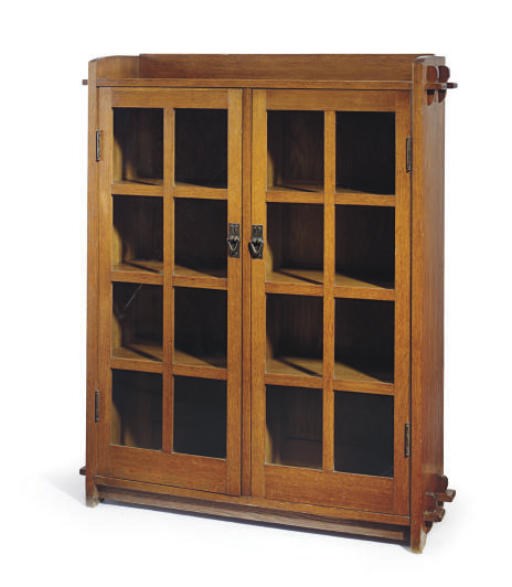 AN OAK AND GLASS BOOKCASE,