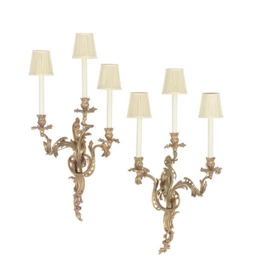 A SET OF TWELVE FRENCH GILT-BRONZE THREE-BRANCH WALL LIGHTS,