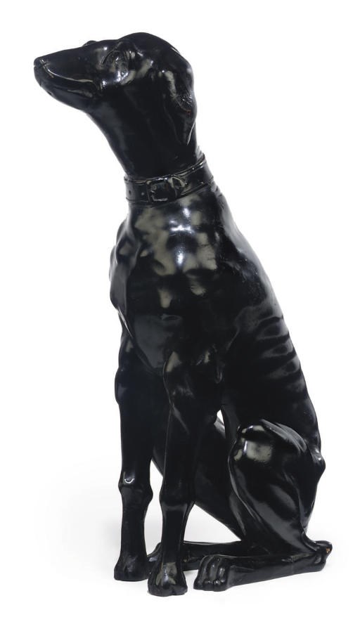 AN ITALIAN EBONISED WOODEN MODEL OF A SEATED DOG