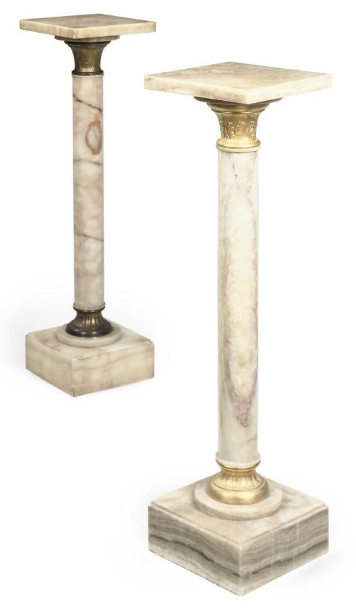 A NEAR PAIR OF FRENCH GILT METAL MOUNTED ONYX PEDESTALS