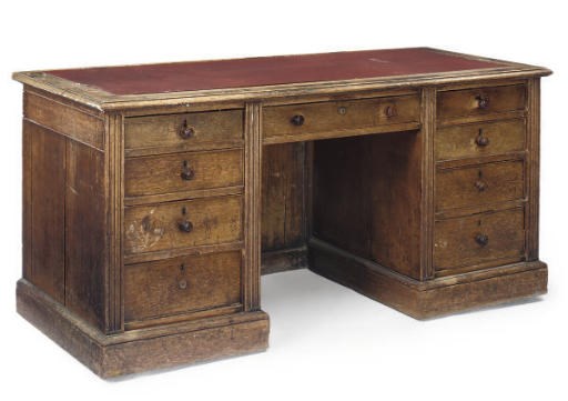 AN EARLY VICTORIAN OAK KNEEHOLE PEDESTAL DESK