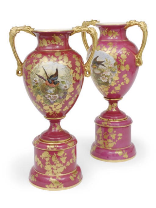 A PAIR OF CONTINENTAL POTTERY TWO-HANDLED VASES AND STANDS