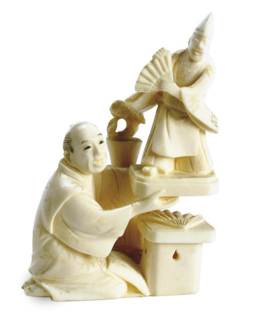A JAPANESE IVORY NETSUKE OF A CARVER WITH A FAN DANCER DOLL,**